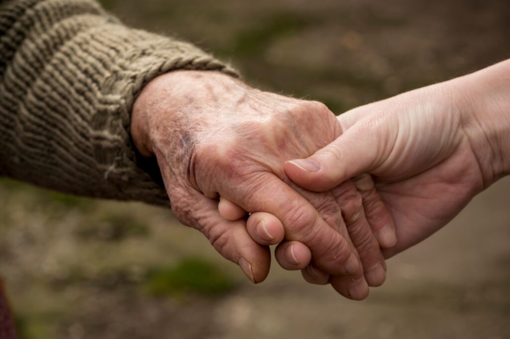 Old and young person holding hands Elderly care and respect - Urifunnel urinary care for caregivers - Urifunnel